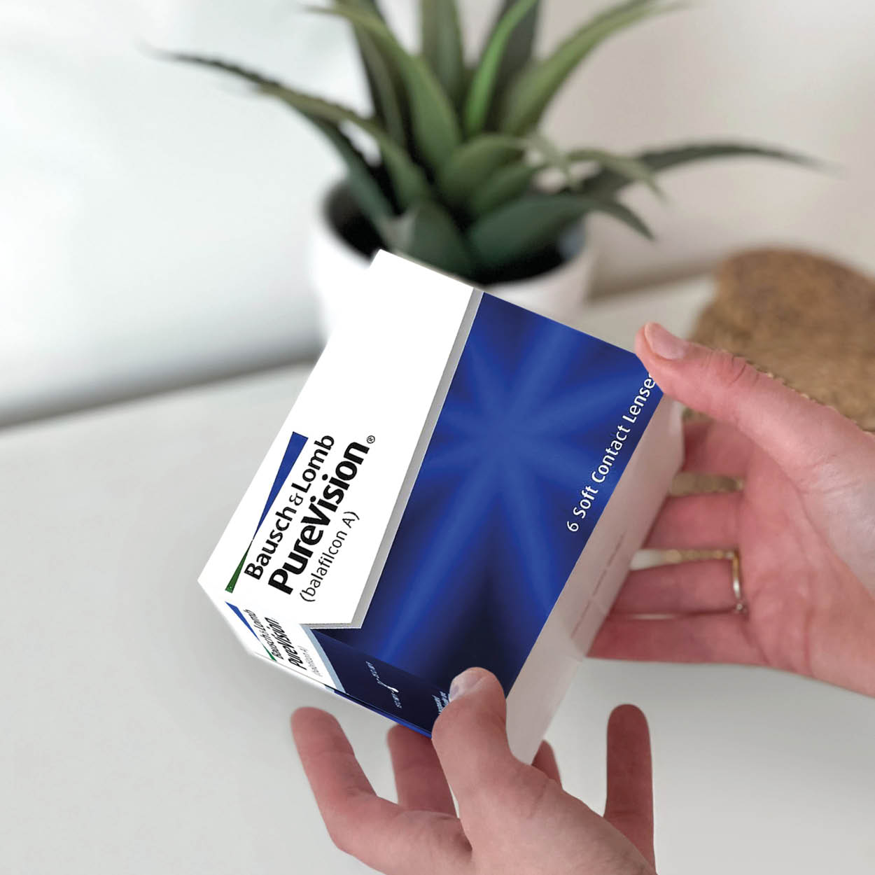 iemand houdt een doosje van purevision vast